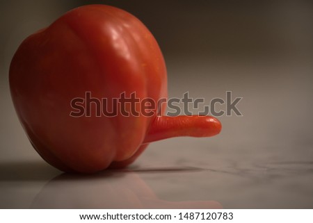Strange tomato with reflection on a marble floor