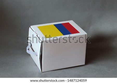 Colombian flag on white box, Paper packaging for put products. The concept of export trading from Colombia.