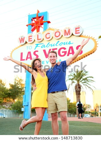 Las Vegas Sign. Couple jumping having fun in front of Welcome to Fabulous Las Vegas sign. Happy people on holidays honeymoon on the Strip, multiracial couple, Caucasian man, Asian woman, Nevada, USA.