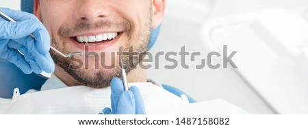 Young man at the dentist. Dental care, taking care of teeth. Picture with copy space for background. Royalty-Free Stock Photo #1487158082