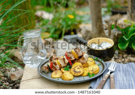 Outside grilling near beautiful garden with pond