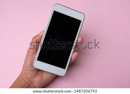 flat lay Woman hands holding smartphone on pink background