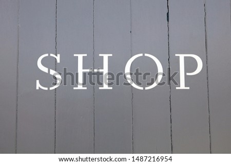 White Painted Letters Spelling Out The Word Shop On A Grey Wooden Background.
