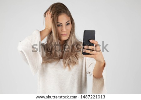 woman having shooting self portrait on front camera of smart phone