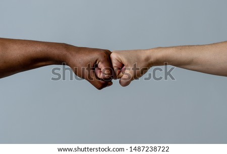 Black African American race male and white Caucasian woman hands giving a fist bump in agreement partnership and cooperation multiracial diversity and immigration concept. Stop racism campaign. Royalty-Free Stock Photo #1487238722