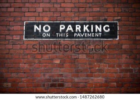 No parking sign at a brick wall.