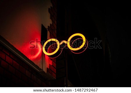 Neon Sign glowing red glasses shape on the street.