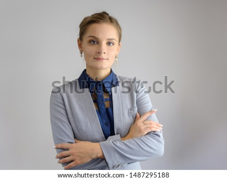 Studio photo a waist-high portrait of a pretty young woman girl in a business suit on a white background. He stands right in front of the camera, explains, with emotion.