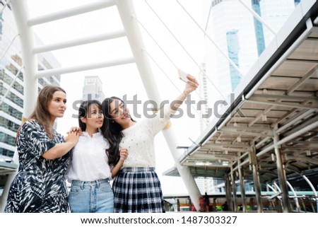 International Women Group Standing happily taking pictures of selfies in the city Summer travel is ideal for finding information from smartphones such as tourist sites, shopping and street food.