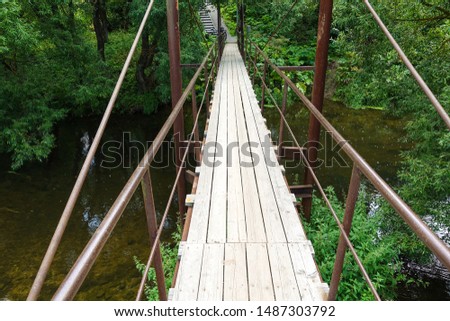 Suspension bridge, Crossing the river, ferriage in the woods Royalty-Free Stock Photo #1487303792