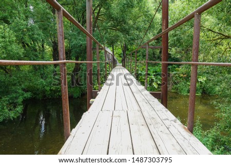 Suspension bridge, Crossing the river, ferriage in the woods Royalty-Free Stock Photo #1487303795