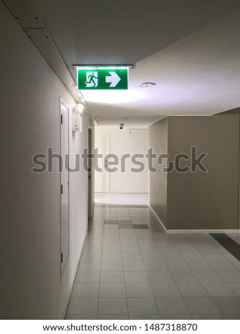 Green emergency exit sign inside the building, escape sign and direction f the exit