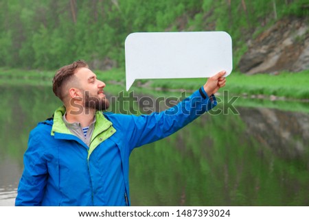Bearded man with a blank white poster over his head