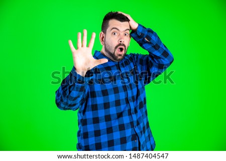 Handsome caucasian guy making really funny expressions with blue shirt