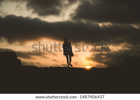silhouette of lonely person walking with sunset