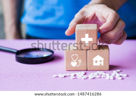 Doctor hand arranging wood block stacking with health care and medical icon, insurance for your health search.