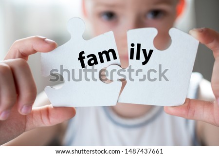 Word family on two puzzles. the child is holding two white puzzles. Family concept. Parents' divorce. Family breakdown