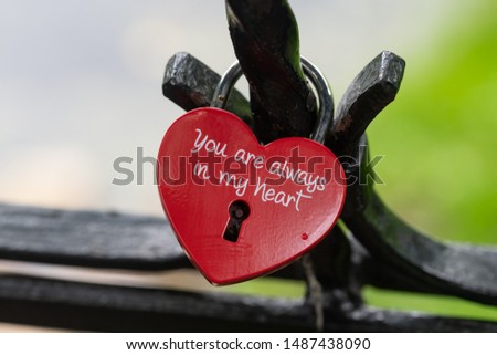 Castle, form of red iron hearts. Closed on the fence forged fence on the bridge. The background behind the water and the waterfront.