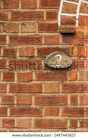 House number 2 on a red brick wall
