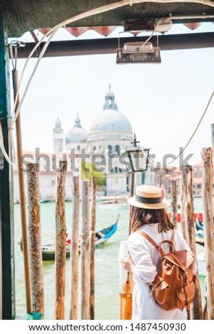 woman in white clothes with straw hat at pier basilica santa maria della salute on background summer vacation