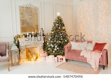 beautiful modern design of the room in delicate light pink colors decorated with Christmas tree and decorative elements, fireplace, lights garlands