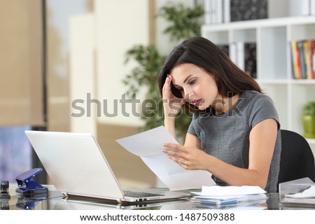 Worried office worker complaining reading bad news in a paper letter Royalty-Free Stock Photo #1487509388