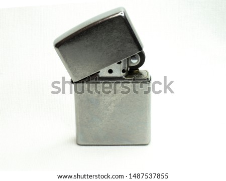 Used vintage chrome gas lighter on a plane white background
