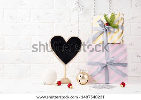 Happy New Year. Christmas gifts, heart-shaped chalk sign for text, decorations and toy on white background.