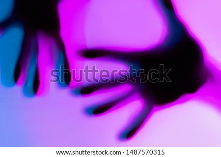 Hands in blue and pink neon light gradient behind white surface. Foggy blurred effect for different concept ideas. Trendy duotone illumination. Abstract background with horizontal orientation.
