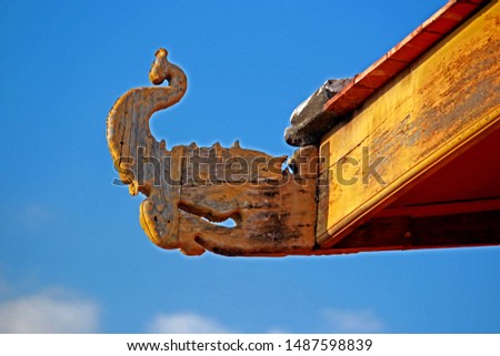 Detail of traditional Thai style wood craving on the roof of Thai temple