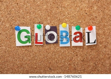 The word Global in cut out magazine letters pinned to a cork notice board. Business,Social Media and News are now all global, live, up to the minute and delivered to the market place at speed 