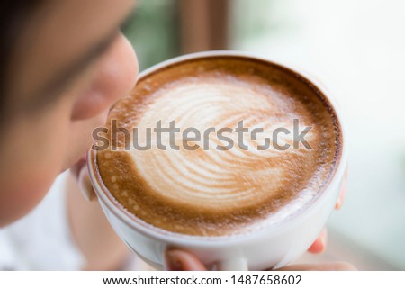 Working women drinking coffee near the window nature background, close up