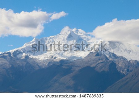 snowy mountains of peru with blue sky and clouds