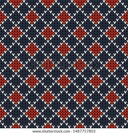 Seamless knitted pattern with rhombuses. Winter knit texture in dark blue, bright red, and white for socks, underwear, mittens, or other fashion textile design.
