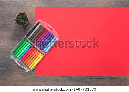 Assorted multicolored rainbow markers office or school set of stationery on red background. Flat lay with copy space. back to school or creative design education craft concept.