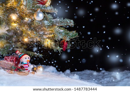 Christmas composition - Christmas tree in the snow, gifts, toy snowman and the inscription Merry Christmas and Happy New Year, copy space, place for text