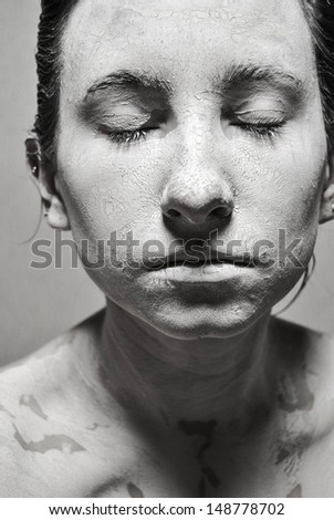 portrait of beauty girl with closed eyes in mud. black and white photography