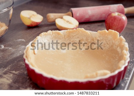 Traditional homemade apple pie and ingredients such as apple and cinnamon on wooden background for autumn holiday
