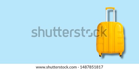 Yellow suitcase on a blue background. Banner. Travel and vacation concept. Flat lay, top view