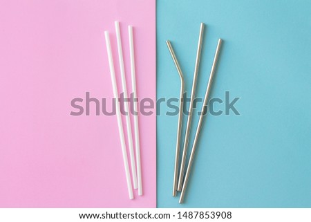 Flat lay of reusable stainless steel straw with plastic straw on pink and blue background. sustainable and zero wast concept.