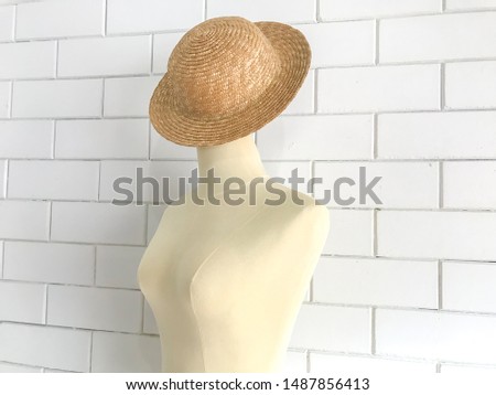 Vintage fashion mannequin stand at white wall.