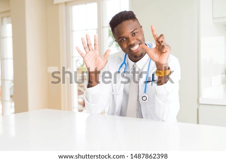 African american doctor man at the clinic showing and pointing up with fingers number seven while smiling confident and happy.