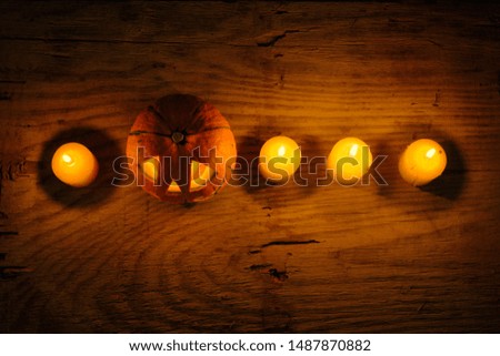 Top view of Halloween pumpkin with candles lights on wooden background
