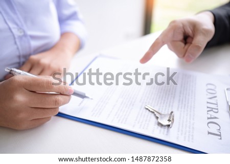 estate agent giving house keys present price for loan investment to home ownership for buy house contract. 