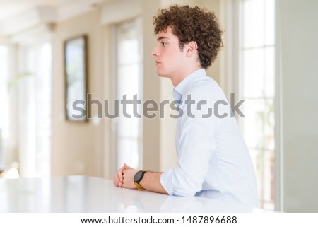 Young business man with curly read head looking to side, relax profile pose with natural face and confident smile.
