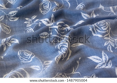 Close up crop view of blue cloth with flower details 