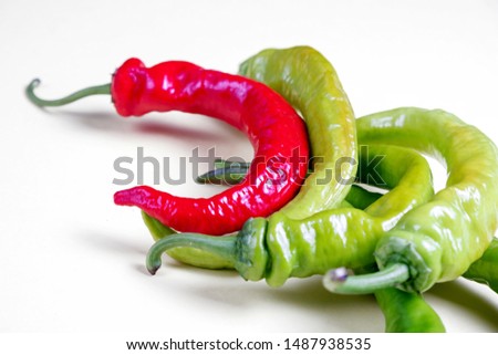 red and green bitter hot peppers on a white background