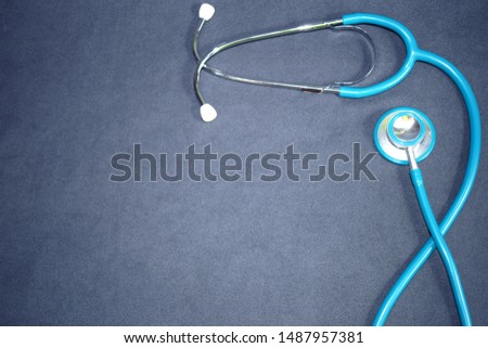  blue stethoscope on a dark gray background Royalty-Free Stock Photo #1487957381