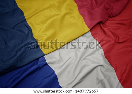 waving colorful flag of france and national flag of chad. macro