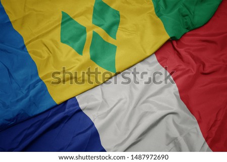 waving colorful flag of france and national flag of saint vincent and the grenadines. macro